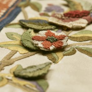 Detailfoto van een met de hand geborduurd bloemetje dat is geappliqueerd op een in het TextielLab machinaal geborduurde sample van de nieuwe gordijnen. Foto: Tommy de Lange i.o.v. TextielMuseum
